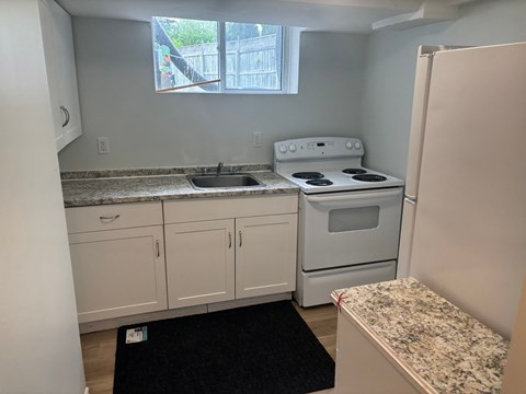 A kitchen with white appliances and cabinets.