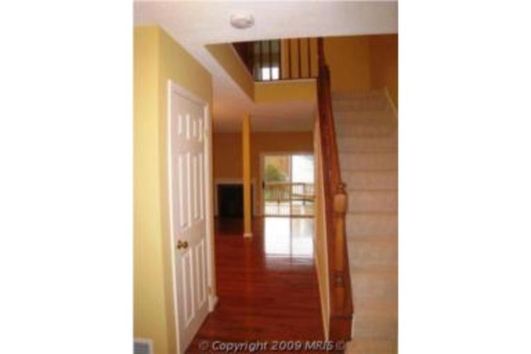 A hallway with a staircase leading to the second floor.