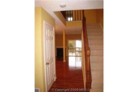 A hallway with a staircase leading to the second floor.