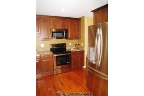 A kitchen with wooden cabinets and a black stove top oven.