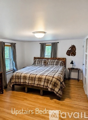 A bedroom with a bed, nightstand, and window.
