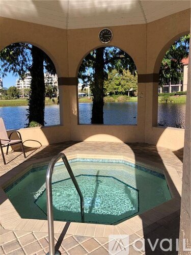 A hot tub is in the middle of a patio with a view of a lake.