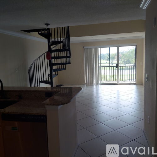 A kitchen with a spiral staircase in the middle of the room.