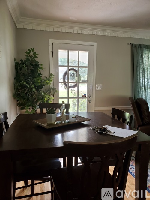 A dining room with a wooden table and chairs.