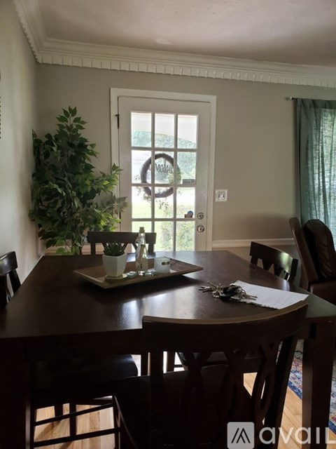 A dining room with a wooden table and chairs.