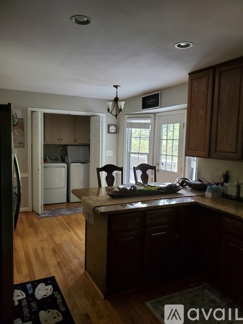 A kitchen with wooden cabinets and a black fridge.