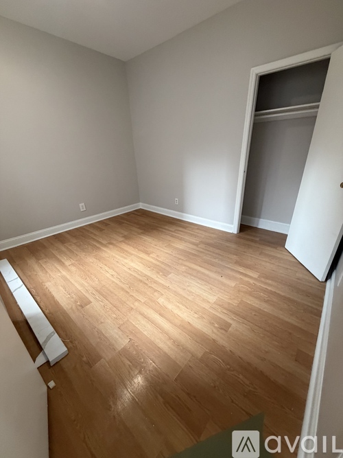 A room with wooden flooring and a white door.