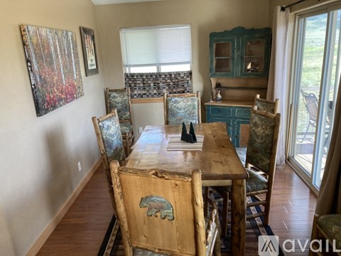 A dining room with a wooden table and chairs.