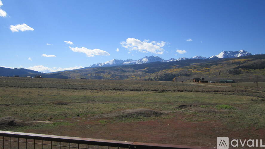 A mountain range stretches across the horizon under a blue sky.