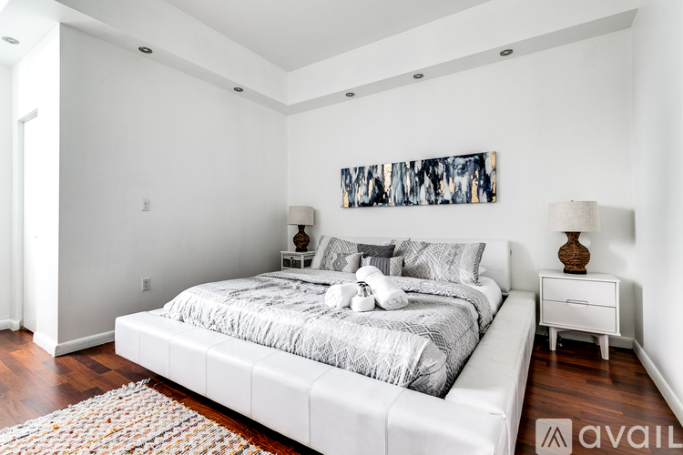 A bedroom with a large bed and a painting on the wall.