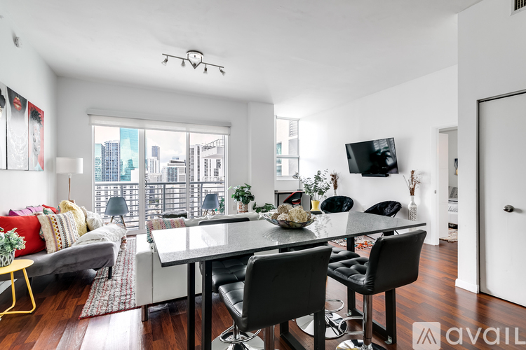 A modern dining room with a glass table and chairs.