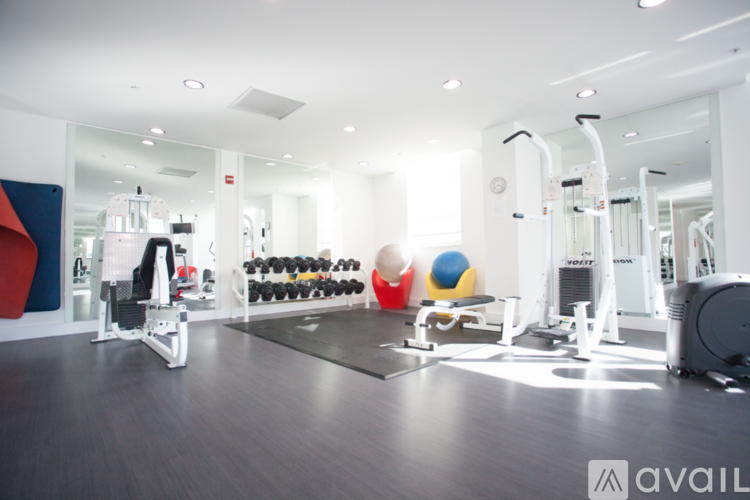 A gym with a variety of equipment including weights, a bench press, and a rowing machine.