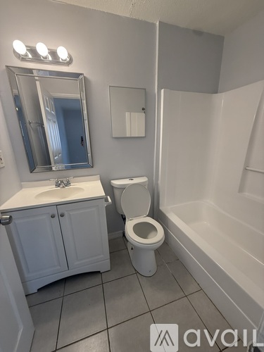 A bathroom with a toilet, sink, and mirror.