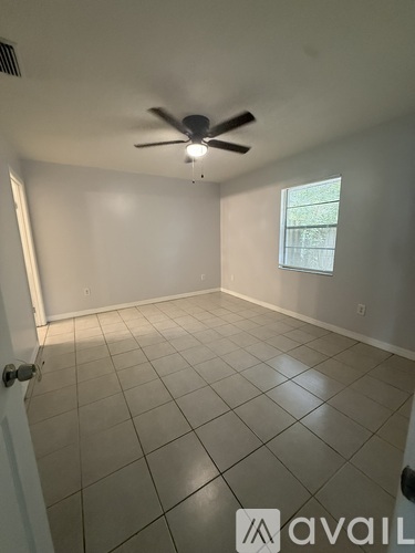 A room with a ceiling fan and a window.