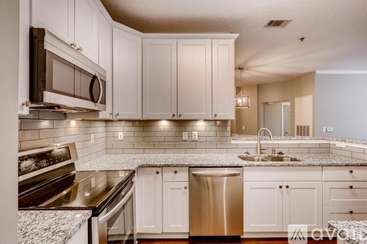 A kitchen with white cabinets and a granite countertop.