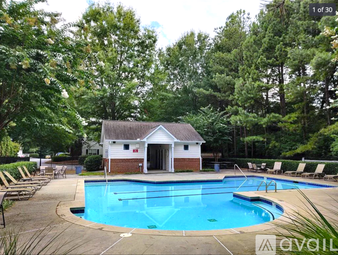 A pool with a small building behind it.