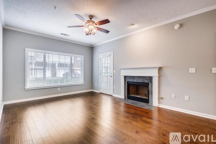 A spacious living room with a fireplace and a ceiling fan.