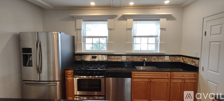 A kitchen with a refrigerator, oven, and sink.