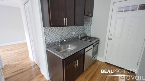 A kitchen with dark brown cabinets and a granite countertop.