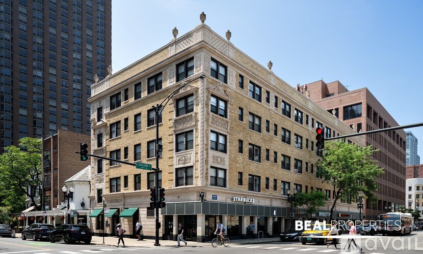 A street view of a city with a building that has a Starbucks on the ground floor.