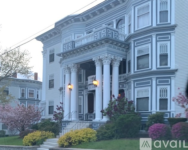 A large white house with a balcony and columns.