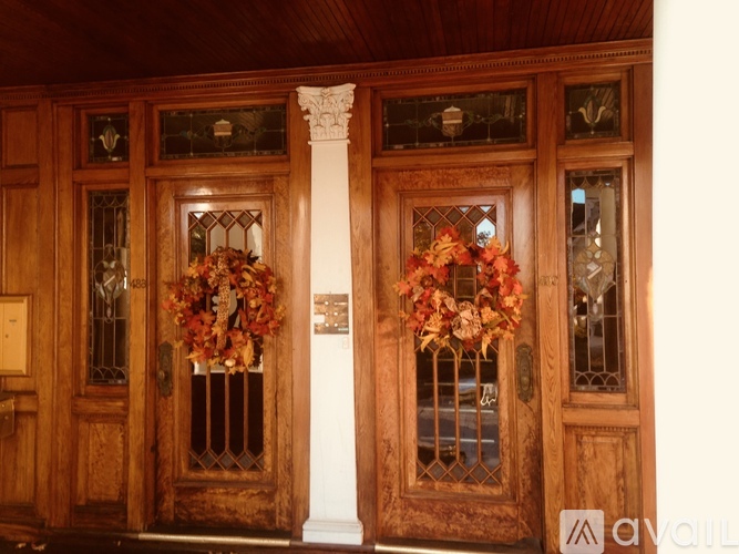 A pair of wooden doors with glass panels and flower decorations.