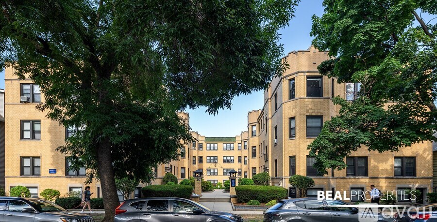 A building with the words "BEAL PROPERTIES" on the side is surrounded by trees and parked cars.