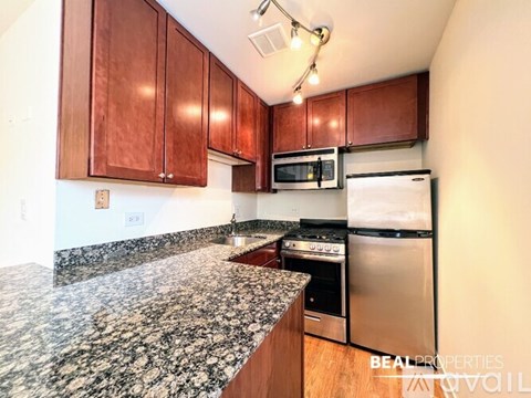 A kitchen with brown cabinets and a granite counter top.