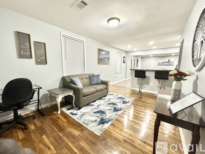 A living room with a couch, chair, and a rug.