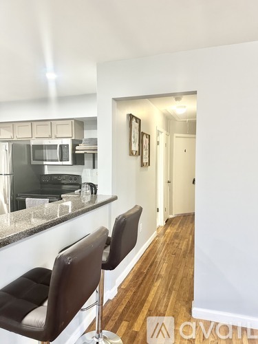 A kitchen with a bar stool and a chair.