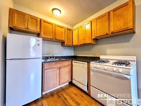 A kitchen with wooden cabinets and a white refrigerator.