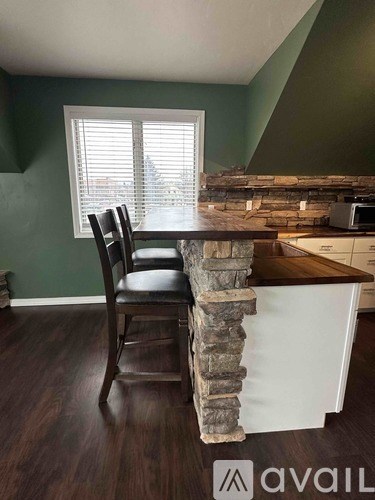 A kitchen with a wooden table and a chair.