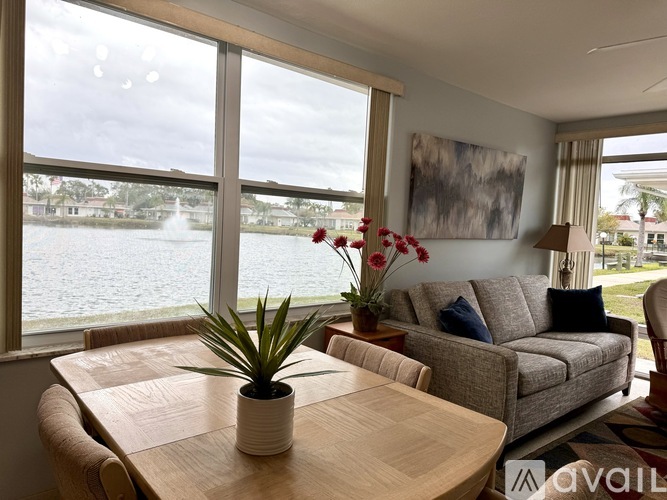 A living room with a view of a lake through large windows.