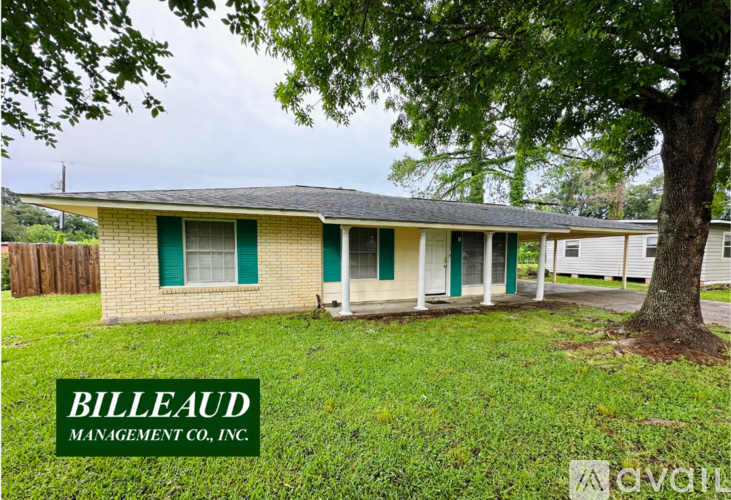 A house with a green lawn and a tree in front of it.