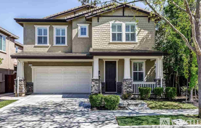 A two-story house with a garage and a driveway.