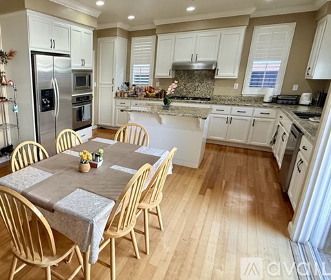 A kitchen with a table and chairs in the middle.