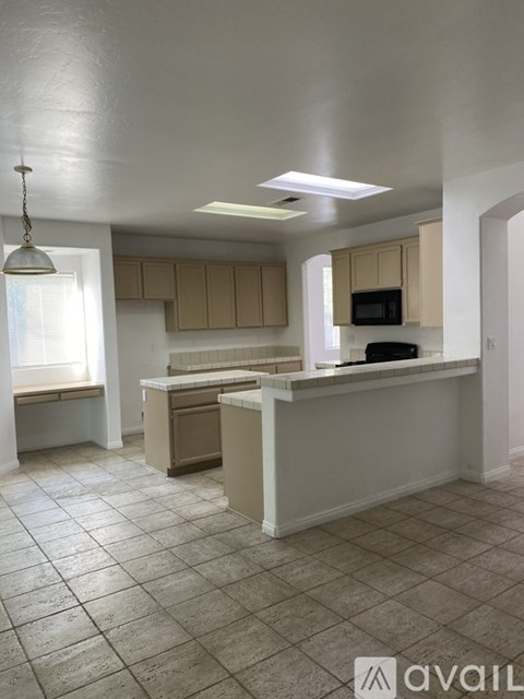 A kitchen with a white counter and cabinets.