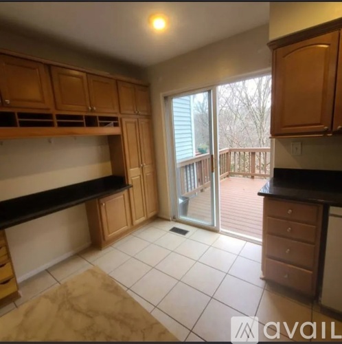 A kitchen with wooden cabinets and a black countertop.