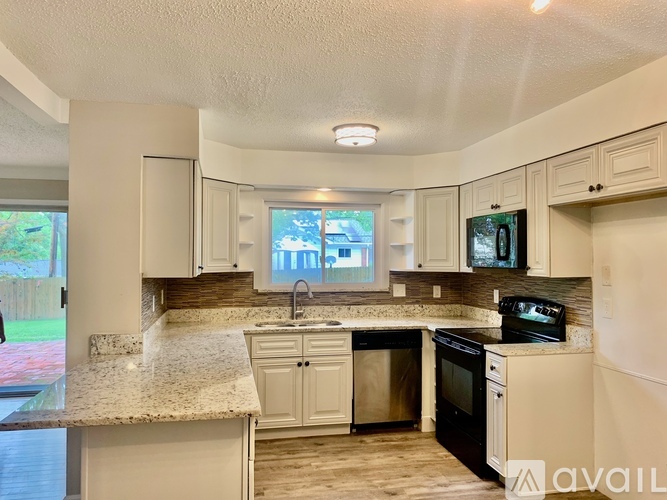 A kitchen with granite countertops and white cabinets.