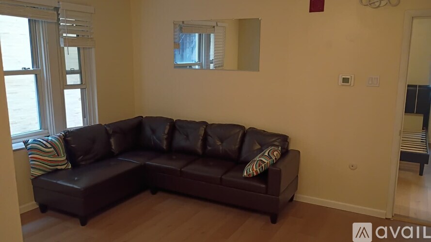 A brown leather sectional sofa with pillows in a living room.