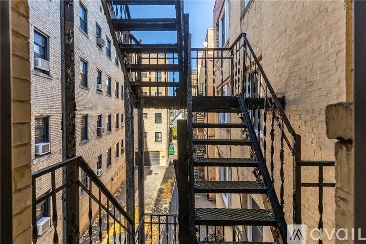 A narrow alleyway with a metal staircase connecting two buildings.