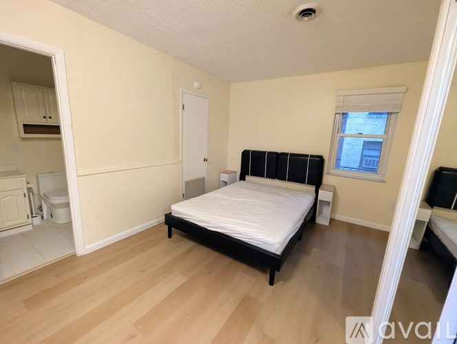 A bedroom with a bed, dresser, and mirror.