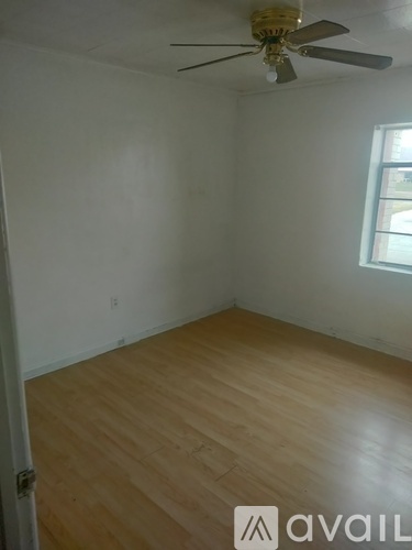 A room with a ceiling fan and wooden flooring.