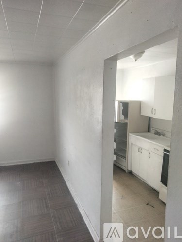 A kitchen with white cabinets and a wooden floor.