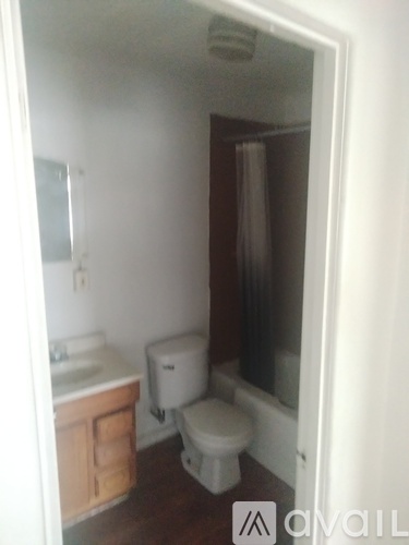 A small bathroom with a toilet, sink and a cabinet.