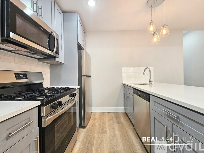 A modern kitchen with a stove top oven and a microwave above it.