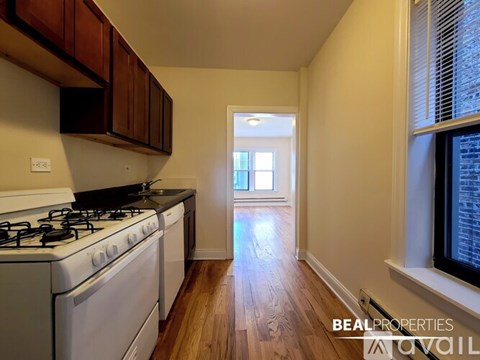 A kitchen with a stove top oven and a window.