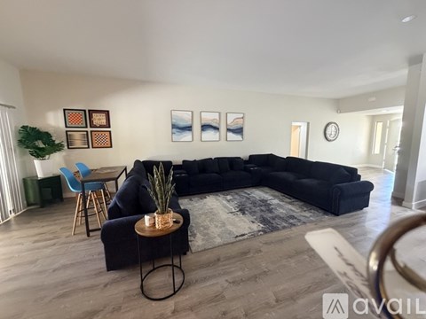 A living room with a black sofa and a wooden coffee table.