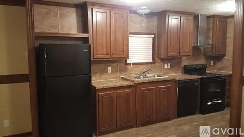 A kitchen with wooden cabinets and black appliances.