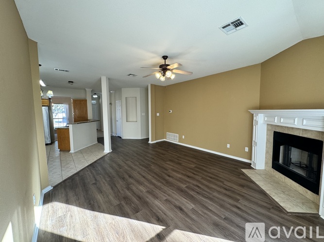A living room with a fireplace and a ceiling fan.